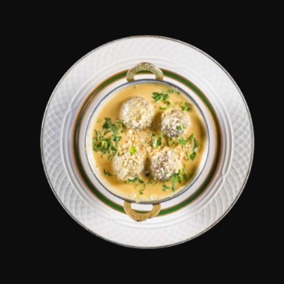 Indian Malai Kofta, vegetable dumplings in a creamy cashew and onion gravy, garnished with cilantro.